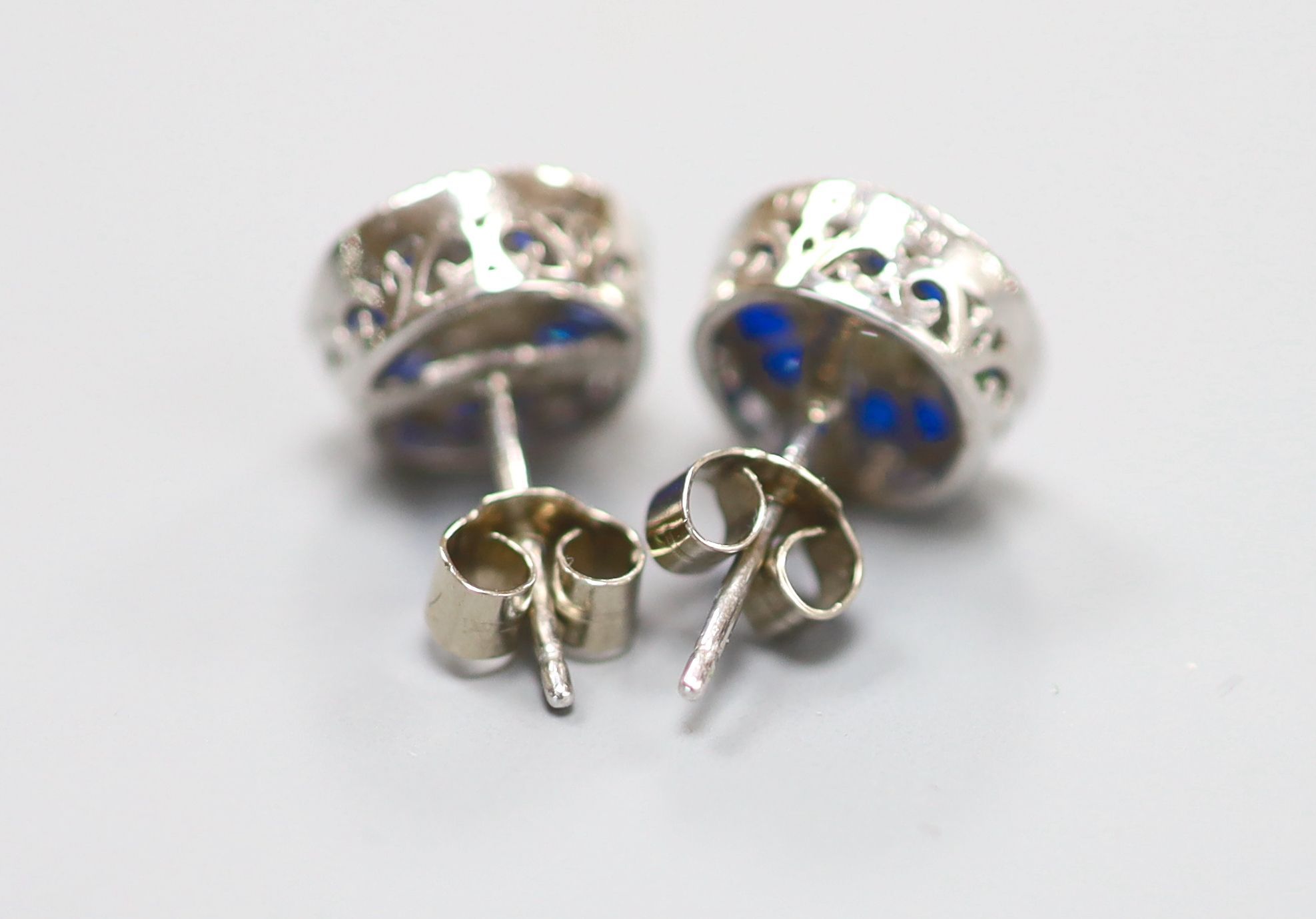 A pair of white metal (stamped China EJI) diamond and synthetic sapphire? set circular cluster earstuds, 10mm, gross 2.4 grams.